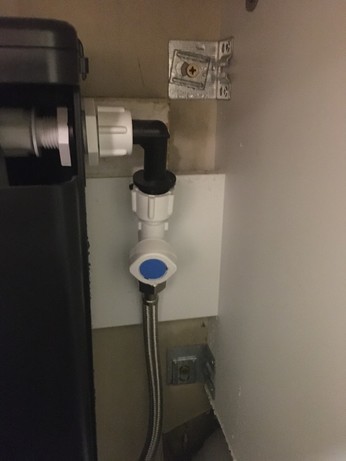 Some mysterious plumbing going into a toilet cistern