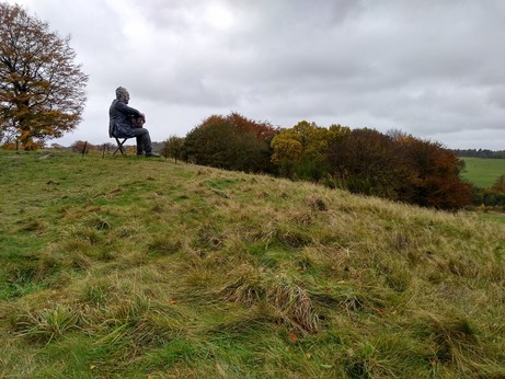 Sculpture on hillside, a larger-than-life seated man