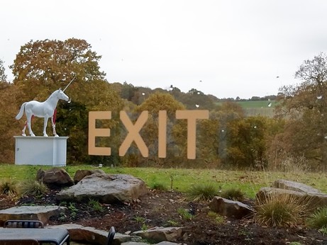 Unicorn sculpture behind glass marked exit