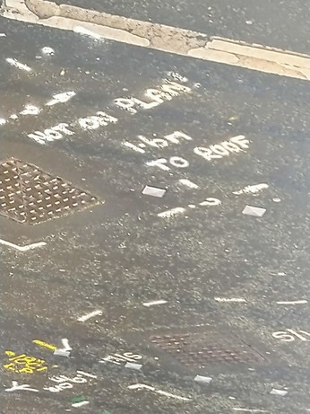 Road surface with spray paint markings: NOT ON PLAN! 1.6M TO ROOF