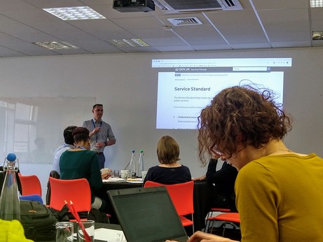 Andrew next to screen displaying the Government Service Standard