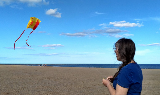Caroline flying a kite on the beach