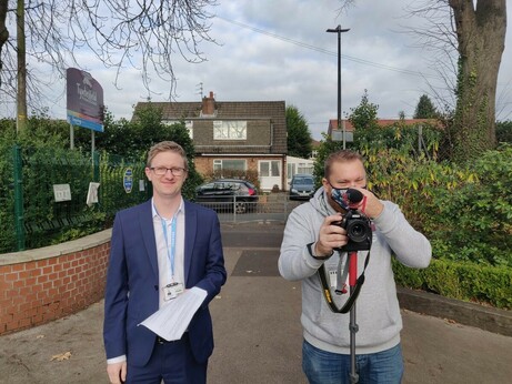 Photo of two men, one with a camera