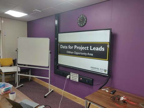 Photograph of a screen and whiteboard in a meeting room