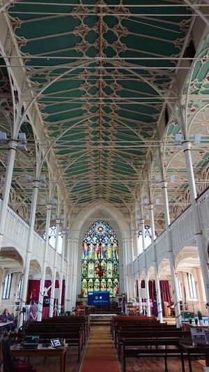 The inside of a church showing the ornate iron columns and decorative ironwork of its construction 