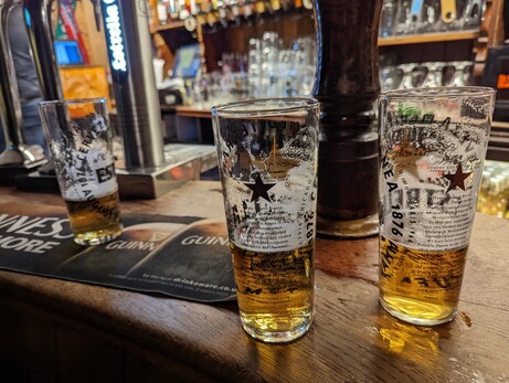 Half empty glasses of beer on a bar