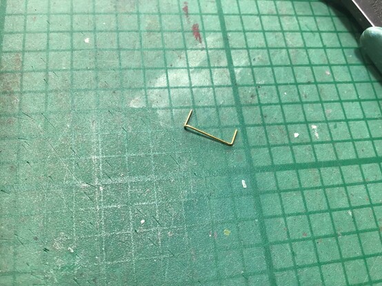 On my scruffy green cutting mat, in splendid isolation, is one fine brass wire handrail. This is bent the right shape, but slightly too long. I’m using it as a template to remind me which way the wire has to bend, because I’m stupid and forget each time I do it!