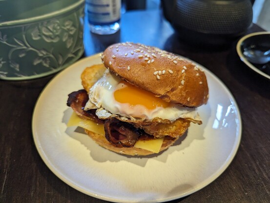 Breakfast bun with hash brown, back and a fried egg in it