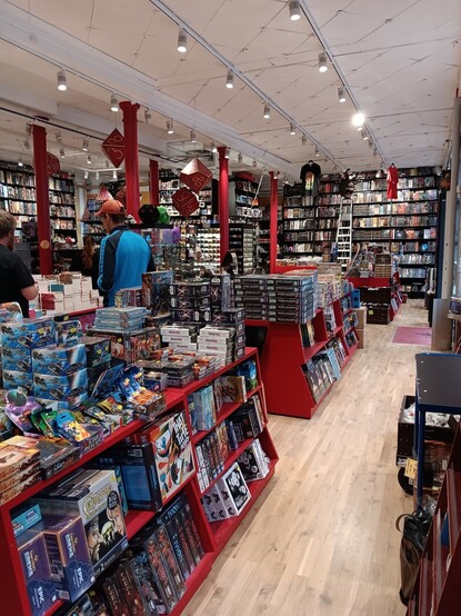 Interior of Faraos Cigarer. Shelves bursting with fresh games and ttrpg stuff.