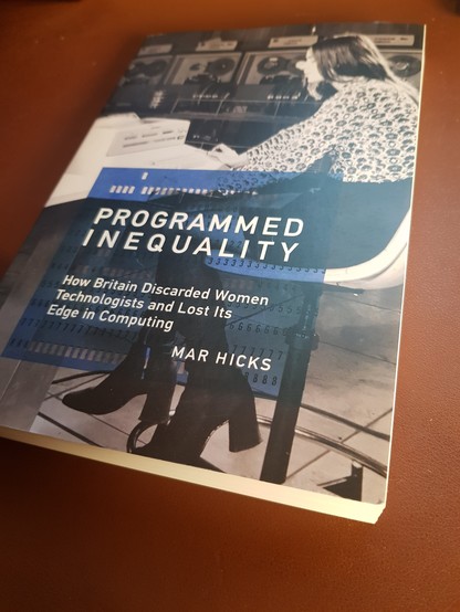Copy of the book "Programmed Inequality" by Mar Hicks on a tan-coloured desk mat