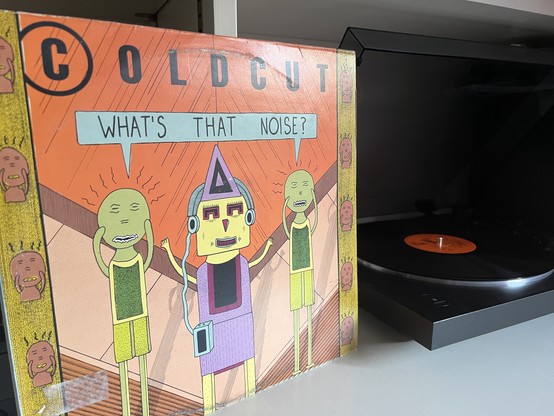 A vinyl copy of What’s that Noise? by Coldcut, on a record player 