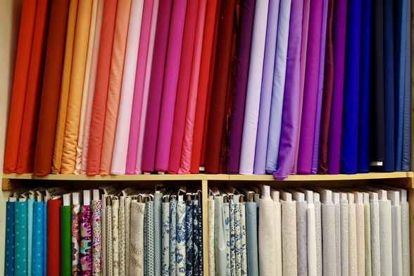 Colourful fabrics lined up on a shelf