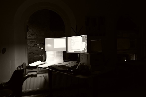 computers, festooned with windows, glow in a darkened room