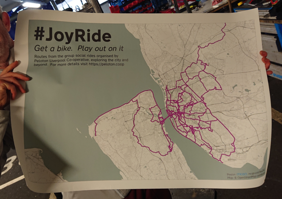 A photo of an A1 poster with a map of Liverpool and surrounding area.  Overlaid are an assortment of routes around the region marked in bright pink