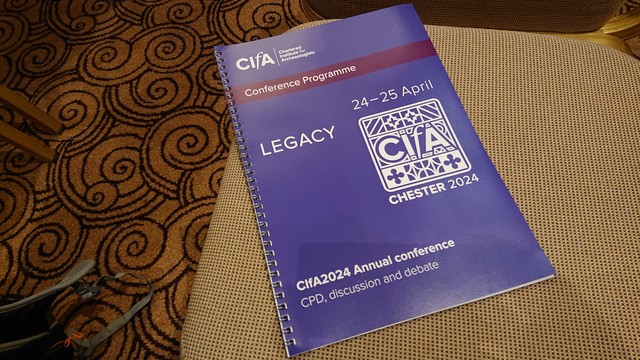 Photo of the programme for the Chartered Institute for Archaeology 2024 conference, resting on a conference chair 