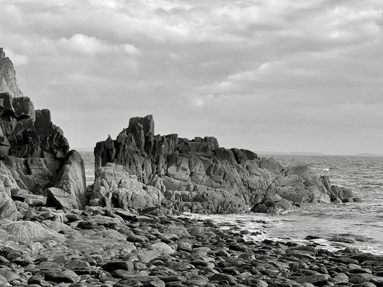 Rocks at Caer Bwdy beach - through a gap, you can see the waves 