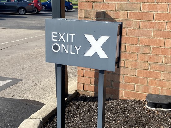 A sign at Starbucks that says Exit Only with a giant X next to it.