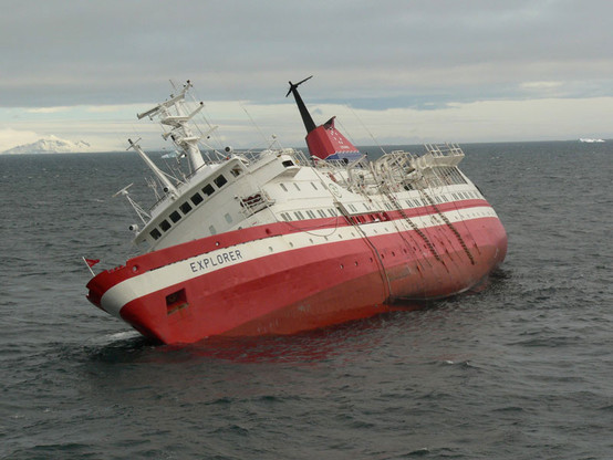 MV Explorer, pictured at an angle that strongly implies evening drinks will be cancelled tonight. Or at the very least sliding sideways along the deck.

The red hulled ship is leaning at about 45 degrees.