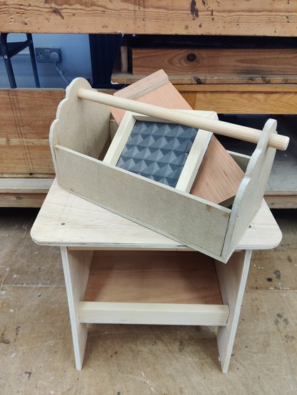 Pile of wood and MDF items, including small picture frame, benchhook, toolbox and workshop stool 