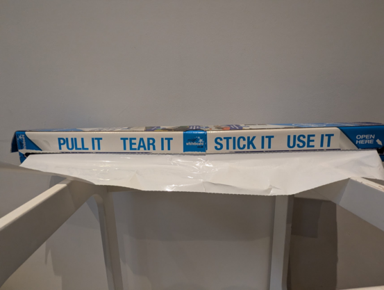 A roll of magic whiteboard (a dry-erase surface that can be attached to walls electrostatically) in a box reading:

Pull It · Tear It · Stick it · Use It