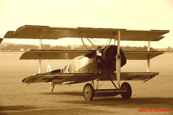 Fokker Dr1 replica on the grass at Duxford. While a generally accurate reproduction this example is powered by a modern engine rather than a 9-cylinder rotary.