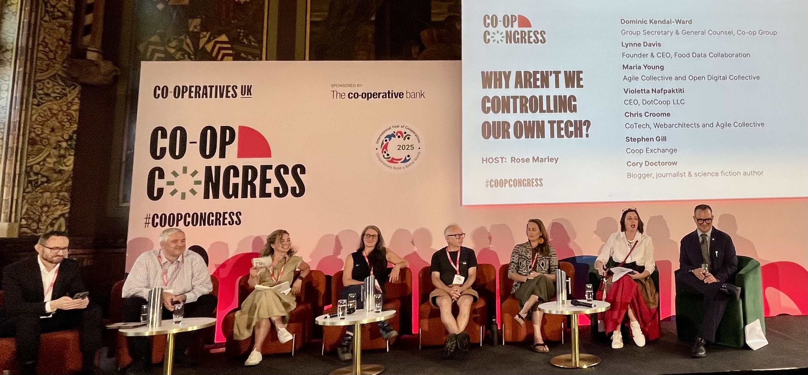 Image features a panel of men and women on a stage at #CoopCongress discussing the subject of ‘Why aren’t we controlling our own tech?’